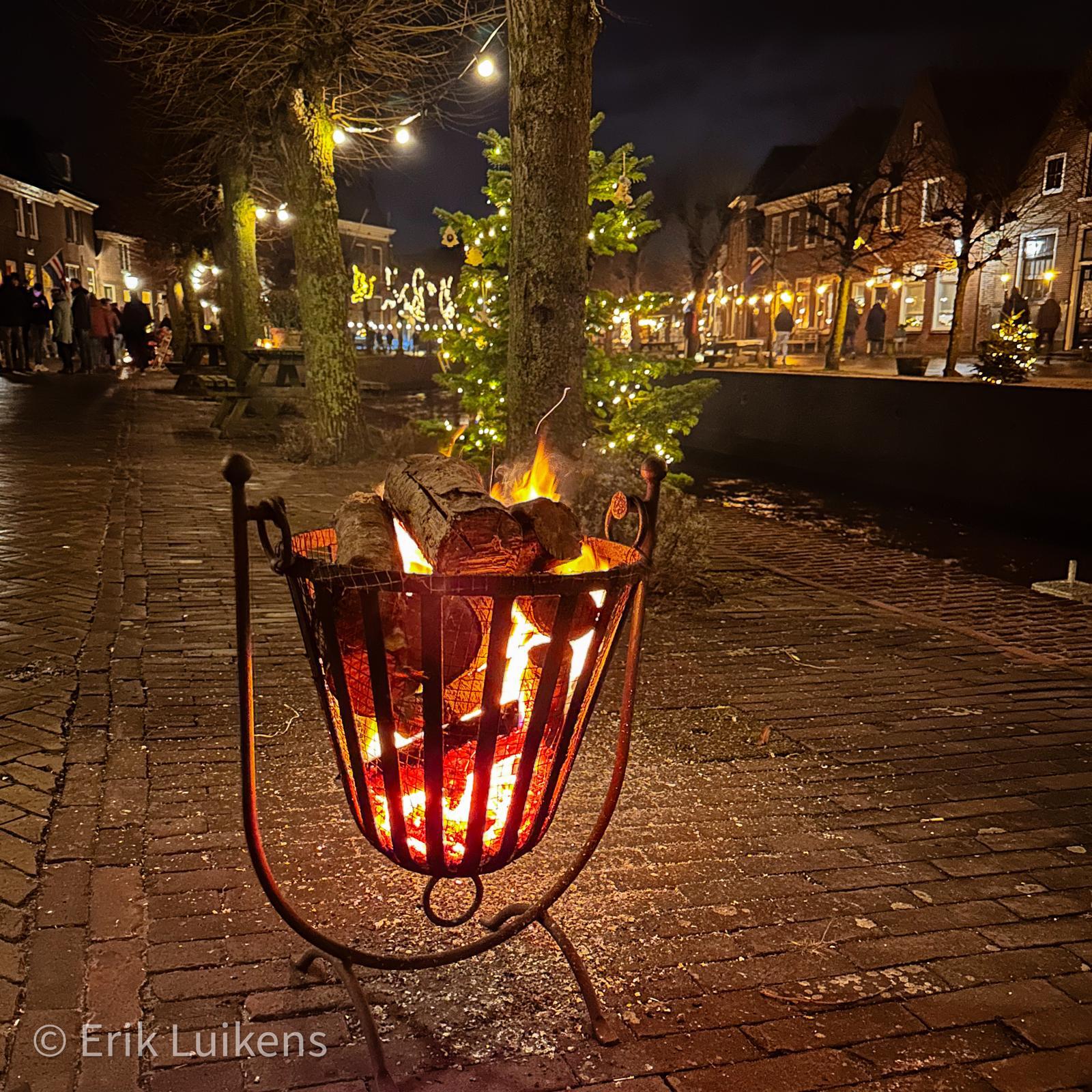 Vuurkorf langs de kade tussen de kerstlichtjes